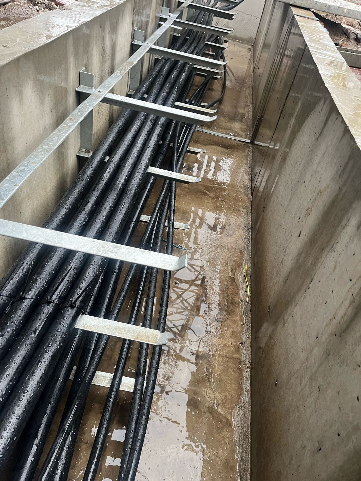 MV power cables laid on galvanised steel brackets in a concrete cable trench